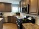 Close-up of the kitchen area, showcasing countertops, appliances, backsplash, and stainless steel sink at 1498 Park Knoll Trl, Lawrenceville, GA 30043