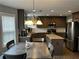 Open concept kitchen featuring a center island, stainless steel appliances, and adjacent dining area at 1498 Park Knoll Trl, Lawrenceville, GA 30043