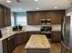 Spacious kitchen boasts granite countertops, stainless appliances, and center island at 1498 Park Knoll Trl, Lawrenceville, GA 30043