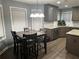 Modern kitchen with stainless steel appliances, granite countertops, island, and adjacent dining area at 1498 Park Knoll Trl, Lawrenceville, GA 30043