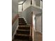 Upward view of the carpeted staircase with white railing and stained wood trim detail at 1498 Park Knoll Trl, Lawrenceville, GA 30043