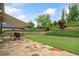 Landscaped backyard featuring a stone patio, lush lawn, mature trees, and terraced landscaping at 406 Horizon Trl, Canton, GA 30114