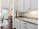 Elegant butler pantry with white cabinetry, granite countertops, and views to adjacent dining area at 406 Horizon Trl, Canton, GA 30114