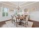 Elegant dining room featuring tray ceiling, wainscoting, chandelier, and hardwood floors at 406 Horizon Trl, Canton, GA 30114