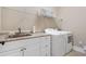 Functional laundry room with sink, cabinetry, and modern washer and dryer at 406 Horizon Trl, Canton, GA 30114