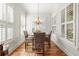 Bright dining room with natural light, hardwood floors, and modern light fixture at 4595 Carriage Walk Ln, Cumming, GA 30040