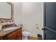 Stylish powder room with granite countertop vanity and decorative mirror, offering functionality at 4595 Carriage Walk Ln, Cumming, GA 30040