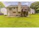Backyard view of the two-story home with a wooden deck, a large patio, and a grassy lawn at 1006 Eagle Vw, Lawrenceville, GA 30044