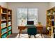 Well-lit home office with a wooden desk, bookshelves, and a comfortable workspace at 1006 Eagle Vw, Lawrenceville, GA 30044