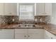 Close-up of the kitchen sink with ample counter space and tile backsplash at 1006 Eagle Vw, Lawrenceville, GA 30044
