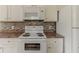Kitchen featuring a white stove, microwave, and matching cabinets, ideal for cooking at 1006 Eagle Vw, Lawrenceville, GA 30044