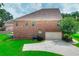 Brick home exterior with a well-manicured lawn, an attached garage, and lush landscaping at 2458 Brook Park Trl, Snellville, GA 30078