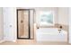 Bright bathroom with a walk-in shower and soaking tub beneath a window at 2458 Brook Park Trl, Snellville, GA 30078