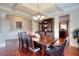 Dining room featuring hardwood floors, coffered ceiling, and stylish chandelier at 2458 Brook Park Trl, Snellville, GA 30078