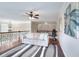 Upstairs living room boasts hardwood floors, a ceiling fan, and decorative artwork at 2458 Brook Park Trl, Snellville, GA 30078