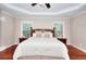 Inviting main bedroom with tray ceiling, hardwood floors, and abundant natural light at 2458 Brook Park Trl, Snellville, GA 30078