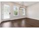 Dining room featuring hardwood floors, a modern light fixture, and abundant natural light from the exterior door at 2461 Sycamore Nw Rd, Atlanta, GA 30318