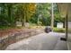 Backyard has a concrete patio, wooden retaining wall, and mature trees at 2790 Laurel Ridge Dr, Decatur, GA 30033