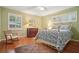 Comfortable bedroom with hardwood floors, patterned rug, rocking chair, and two bright windows at 2790 Laurel Ridge Dr, Decatur, GA 30033