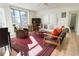Bright living room featuring a red patterned rug, comfortable seating, and a large window with city views at 300 Peachtree Ne St # 24F, Atlanta, GA 30308