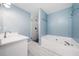 Bright bathroom with bathtub, walk-in shower, light blue walls, and patterned tile floors at 327 Red Fox Dr, Canton, GA 30114