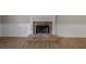 Close-up on the stone fireplace and beautiful wood flooring in a naturally lit living room at 327 Red Fox Dr, Canton, GA 30114