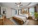 Spacious main bedroom featuring tray ceilings, wood floors, a barn door to ensuite, and a ceiling fan at 327 Red Fox Dr, Canton, GA 30114
