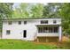 Back exterior of home with an enclosed porch overlooking a large backyard at 3530 Turner Heights Dr, Decatur, GA 30032