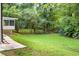 Lush backyard area with green grass, mature trees, and screened in porch at 3530 Turner Heights Dr, Decatur, GA 30032