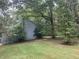 Back of home viewed through large trees and spacious backyard at 408 Hasty Trl, Canton, GA 30115