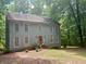 Charming two-story home with wood siding nestled among mature trees at 408 Hasty Trl, Canton, GA 30115