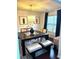 Bright dining room with square table, padded bench, and elegant light fixture at 7178 Glaspie Way, Atlanta, GA 30349