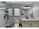 Well-lit bathroom with a modern vanity, toilet, and glass-enclosed shower at 2410 Melton Common Dr, Dacula, GA 30019