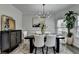 Elegant dining room featuring modern light fixture, wainscoting, chic decor, and a beautiful dining table at 2410 Melton Common Dr, Dacula, GA 30019