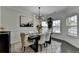 Elegant dining room with modern chandelier, stylish furniture, and plenty of natural light from the windows at 2410 Melton Common Dr, Dacula, GA 30019