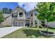 Charming two-story brick home featuring a well-maintained lawn and an attached two-car garage at 2410 Melton Common Dr, Dacula, GA 30019