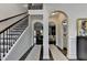 Spacious foyer featuring staircase with iron spindles, access to multiple rooms, and dark hardwood floors at 2410 Melton Common Dr, Dacula, GA 30019