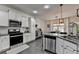 Well-lit kitchen with white cabinetry, granite countertops, and stainless steel appliances, ideal for cooking and entertaining guests at 2410 Melton Common Dr, Dacula, GA 30019