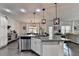 Open kitchen features a granite island with seating, stainless steel appliances, and views to the living area at 2410 Melton Common Dr, Dacula, GA 30019