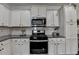 This modern kitchen offers white cabinets, stainless steel appliances, granite countertops, and a gas range at 2410 Melton Common Dr, Dacula, GA 30019