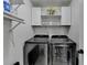 Modern laundry room with front load stainless steel washer and dryer, plus wash and dry signage at 2410 Melton Common Dr, Dacula, GA 30019