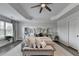 Bright main bedroom with decorative tray ceiling, ceiling fan, and neutral colors at 2410 Melton Common Dr, Dacula, GA 30019