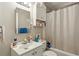 Bathroom featuring white fixtures, mirrored cabinet, and a shower with a white curtain at 428 Medlock Rd, Decatur, GA 30030