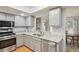 Bright kitchen with stainless steel appliances, gray cabinets, granite countertops, and pass-through to the dining area at 67 Middleton Se Ct, Smyrna, GA 30080