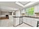 Bright kitchen with a skylight, white cabinets, tile backsplash and a view into the living room at 1386 Heritage Glen Dr, Marietta, GA 30068