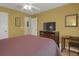 Comfortable bedroom features hardwood floors, ceiling fan, and television atop wooden dresser at 2145 Charleston Oak Cir, Lawrenceville, GA 30043