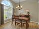 Bright dining room featuring hardwood floors, a large arched window, and traditional chandelier at 2145 Charleston Oak Cir, Lawrenceville, GA 30043
