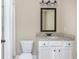 Well-lit bathroom with white cabinetry, granite countertop, framed mirror, and a toilet adjacent to a shower at 516 Black Horse Cir, Canton, GA 30114