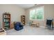Bright bedroom featuring a blue chair, wood shelves, carpeted floor, and natural light from a large window at 516 Black Horse Cir, Canton, GA 30114