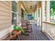 Relaxing front porch with rocking chairs, dark wood flooring, and painted support columns at 516 Black Horse Cir, Canton, GA 30114